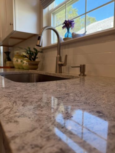 Shiny kitchen countertop with a sink and faucet.