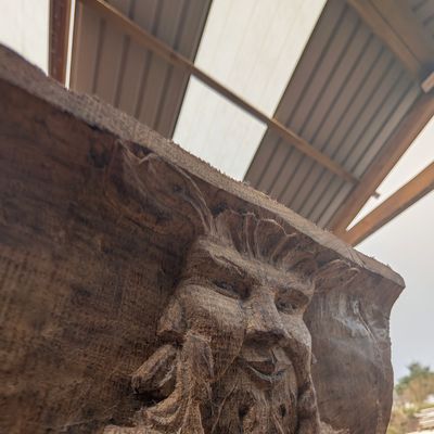 Close-up of a wooden sculpture with a bearded face.