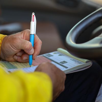 Person filling out form in a car.