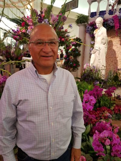 Man standing in front of flower garden