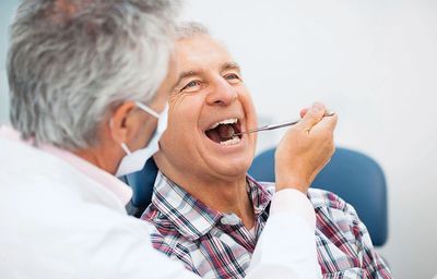 Man in dental chare and Dentist exam