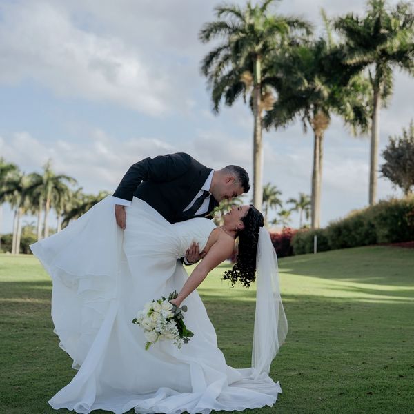Bride and groom romantically posing outdoors.