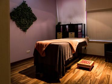 Cozy massage room with warm lighting and wooden flooring.