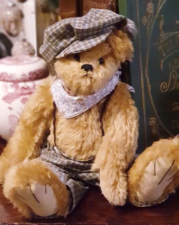 Handmade mohair bear in checked breeches and cap with braces.