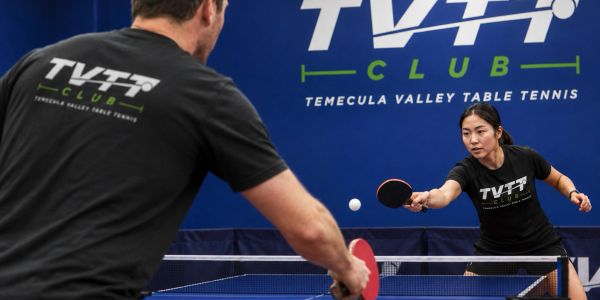 Two players intensely competing in a table tennis match at TVTT Club.