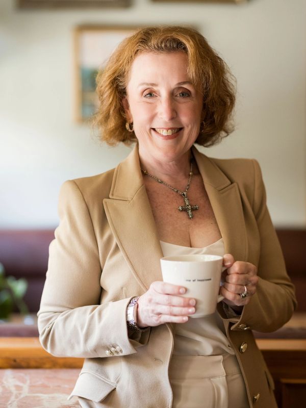JoAnn Andrews offering a warm cup of coffee, inviting women into a moment of clarity and reset.