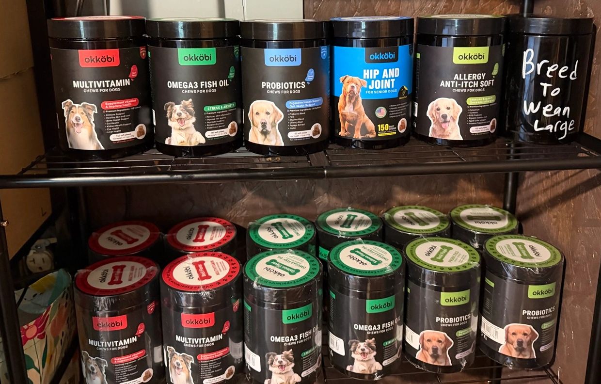 Containers of Okköbi dog supplements arranged on shelves.
