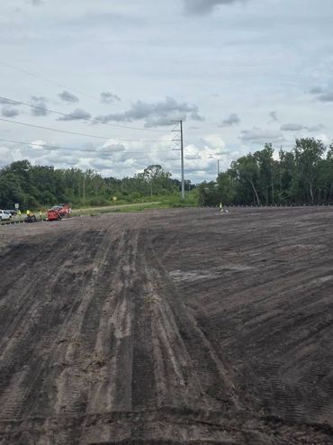 Cleared and leveled land with some land clearing John Deere vehicles.