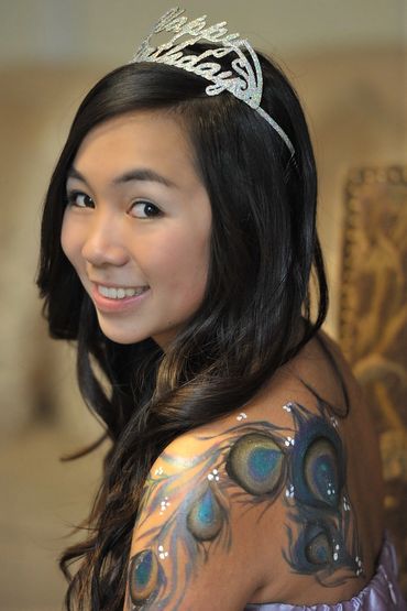 Close up of pretty teenaged girl with a crown looking backwards at the photographer.
