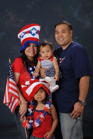 Photobooth shot of family in 4th of July themed attire and fun props.