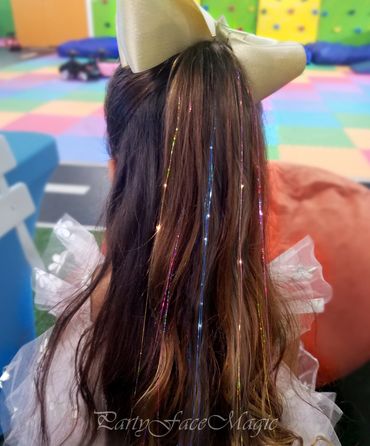 Yellow, blue and pink hair tinsels applied to the birthday girl's ponytail.
