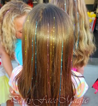 Birthday girl showing off her colorful bright hair tinsels.