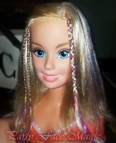 Barbie head mannequin with her braid and hair tinsels.