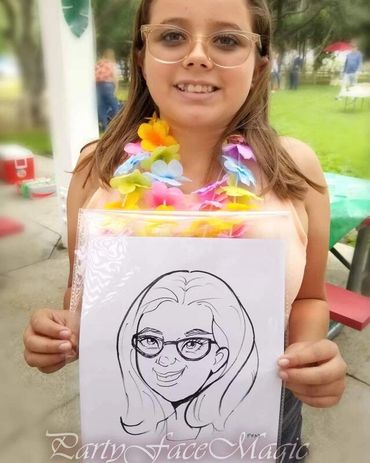 Girl holding a caricature drawing of herself at an outdoor event.