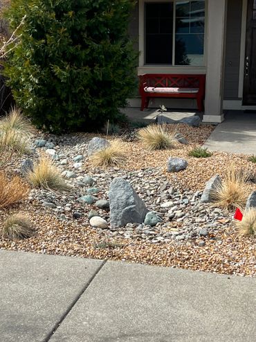 Front yard with rock garden and red bench on porch.