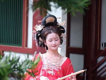 A woman in traditional Chinese attire playing a musical instrument.