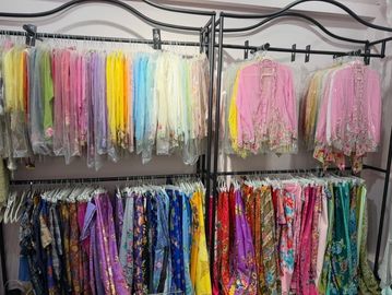 Colorful fabrics and garments neatly arranged on racks in a store.