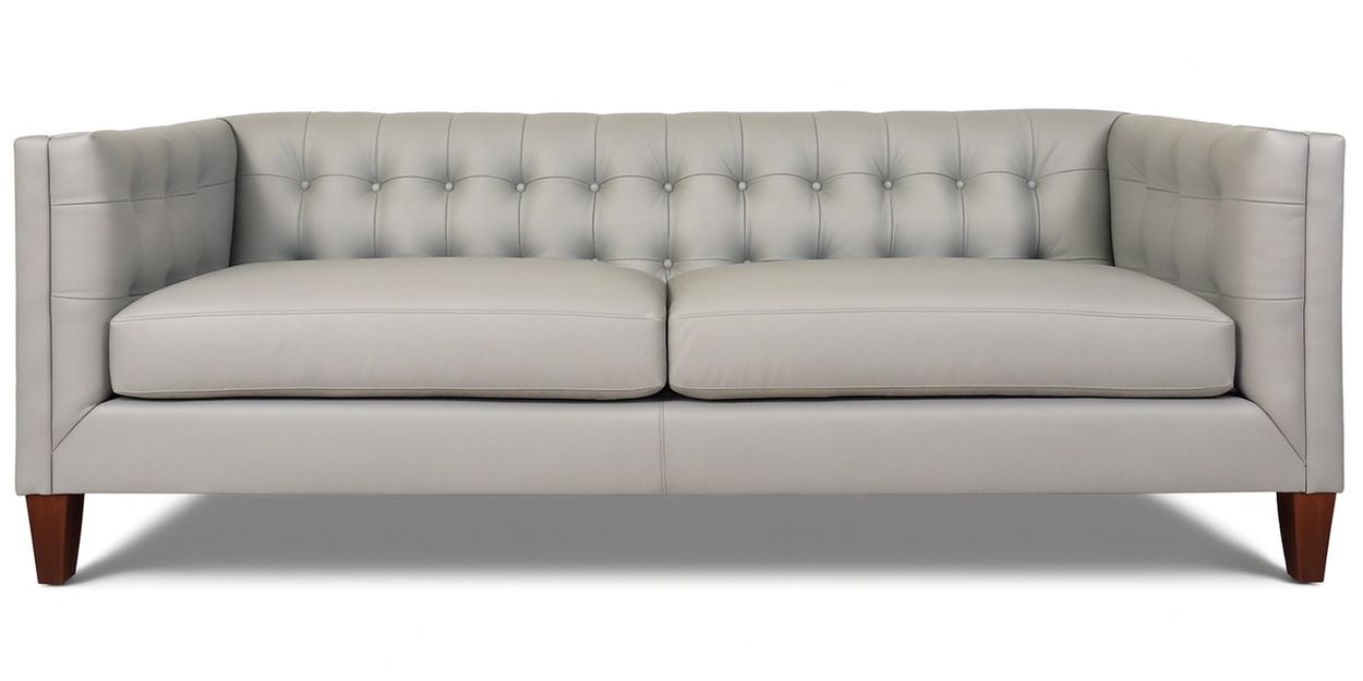Elegant light gray tufted leather sofa with wooden legs.