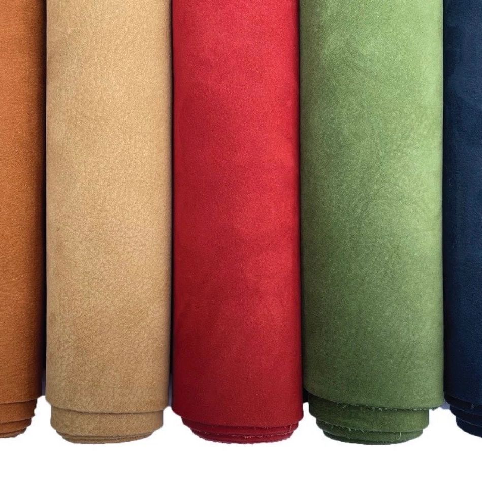 Five rolls of fabric in brown, beige, red, green, and navy blue colors.