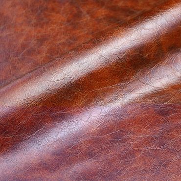 Close-up of shiny brown leather texture with natural creases.