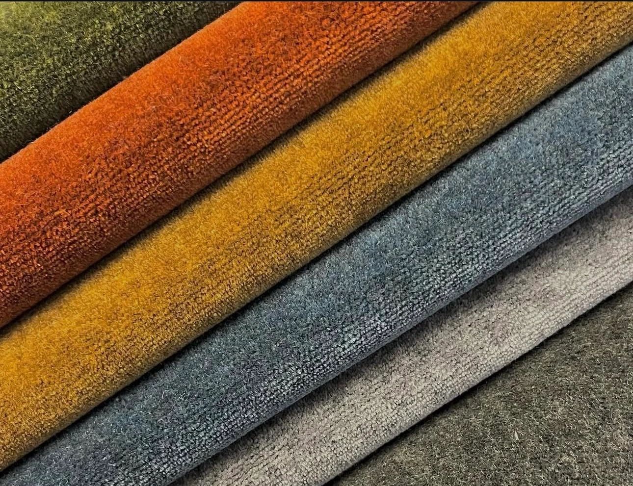 Close-up of colorful, textured fabric rolls in autumn tones.