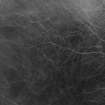 Close-up of black leather texture with natural creases and wrinkles.