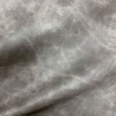 Close-up of textured gray leather surface with natural wrinkles and creases.