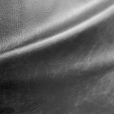 Close-up of textured black leather with natural creases and folds.