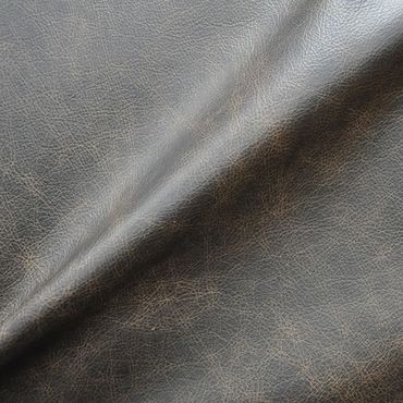 Close-up of textured dark brown leather fabric with natural creases.