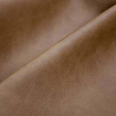 Close-up of light brown leather texture with natural grain.