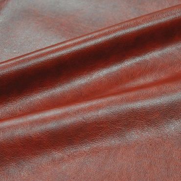 Close-up of textured reddish-brown leather fabric with natural creases.