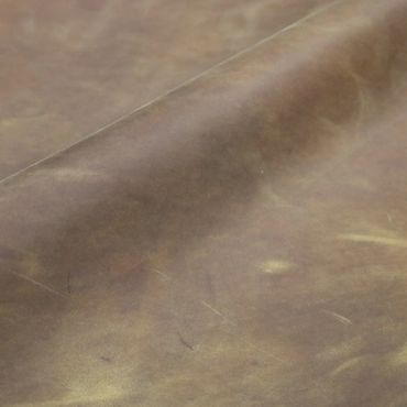 Close-up of distressed brown leather with natural creases and slight scratches.