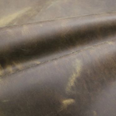Close-up of textured brown leather with natural creases and sheen.