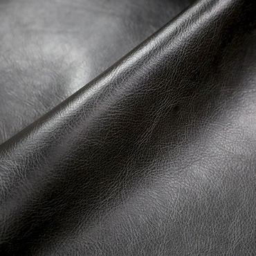 Close-up of smooth black leather texture with natural grain.