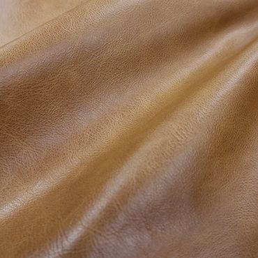 Close-up of smooth, tan leather texture with natural grain and folds.