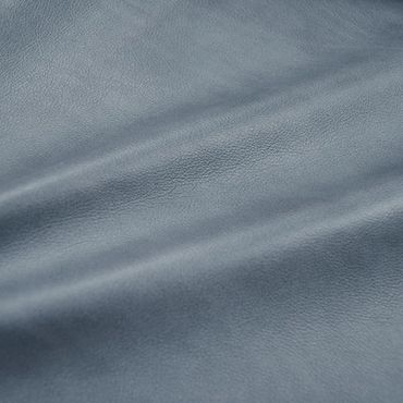 Close-up of textured blue-gray leather fabric with natural wrinkles.