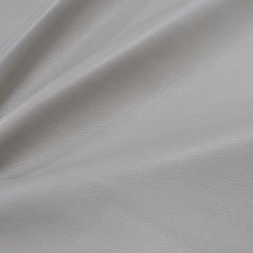 Close-up of smooth gray leather fabric with subtle texture and folds.