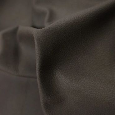 Close-up of textured dark brown leather fabric with folds.