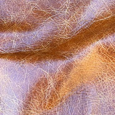 Close-up of textured brown leather with natural creases and wrinkles.