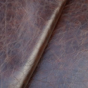 Close-up of textured brown leather material with natural creases.