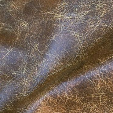 Close-up of textured brown leather with natural wrinkles and creases.