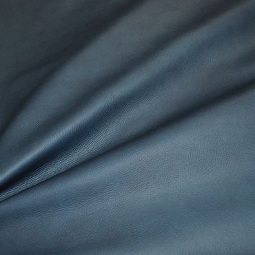 Close-up of smooth blue leather fabric with natural texture.