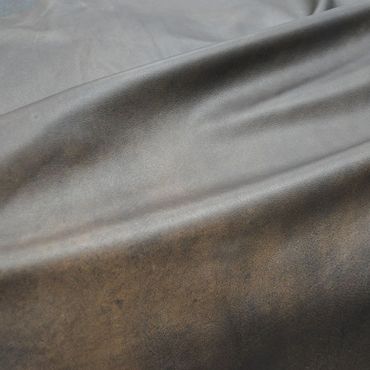 Close-up of smooth brown leather with natural wrinkles.