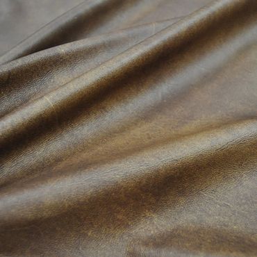 Close-up of textured brown leather fabric with natural folds.