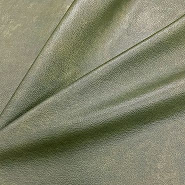 Close-up of green leather fabric with visible texture and folds.