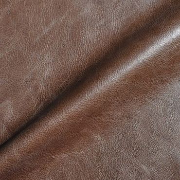 Close-up of textured brown leather fabric with natural grain.