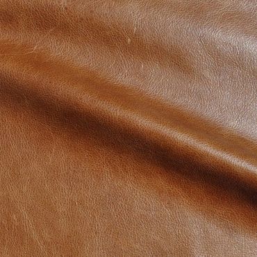 Close-up of textured brown leather surface with natural creases.
