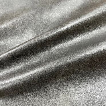Close-up of shiny gray leather fabric with natural creases and texture.