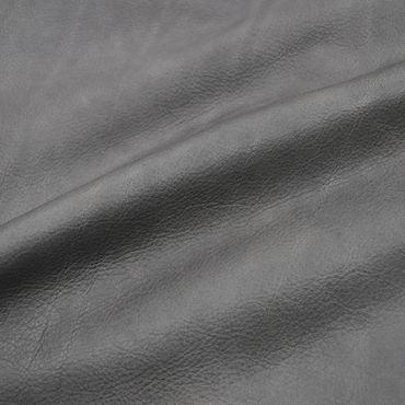 Close-up of textured gray leather fabric with natural wrinkles.
