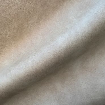 Close-up of textured beige leather material with natural grain patterns.